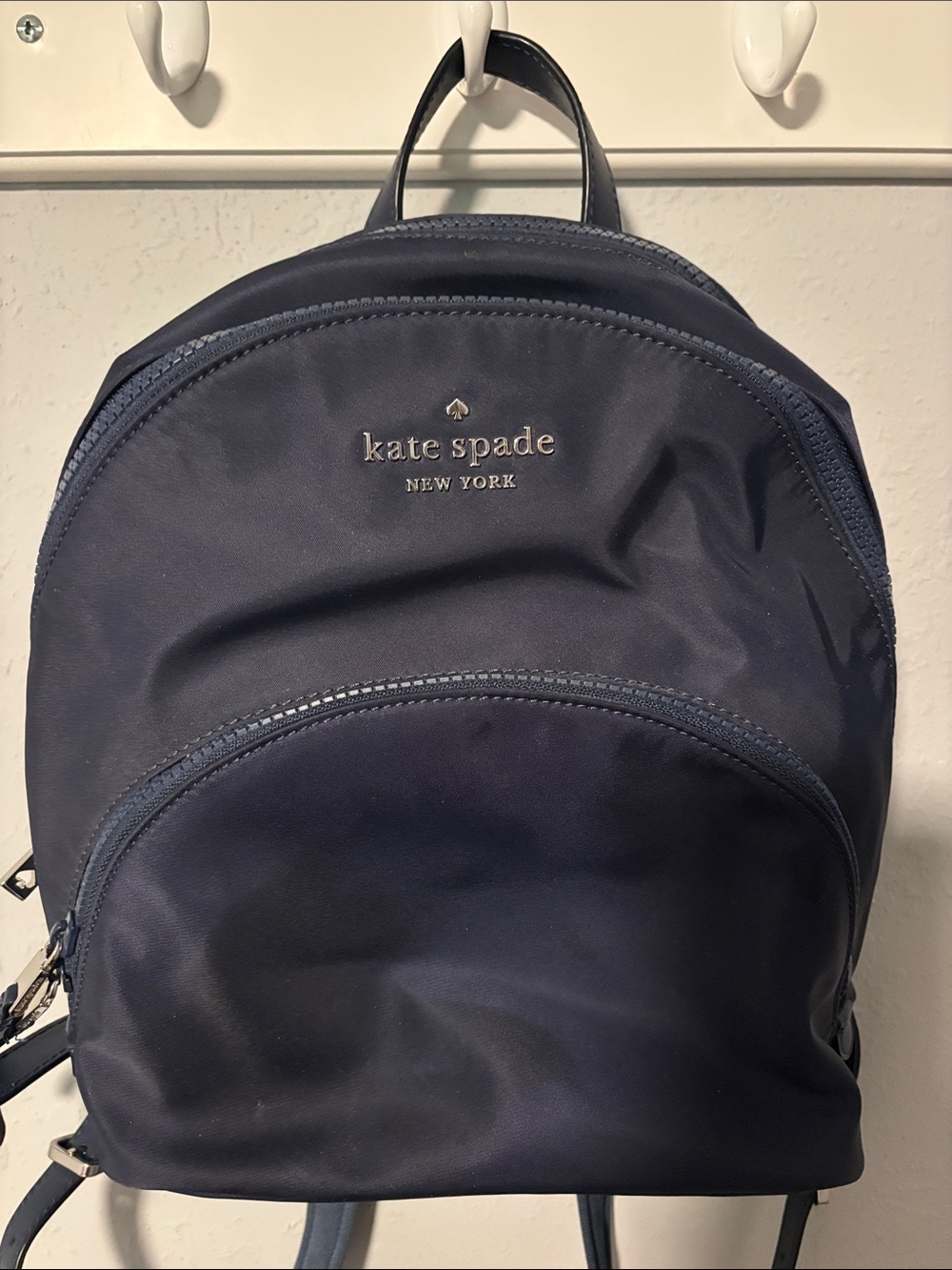 kate spade navy blue woman’s backpack with silver logo